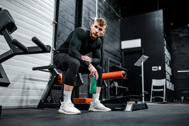 a man chilling sitting in the gym